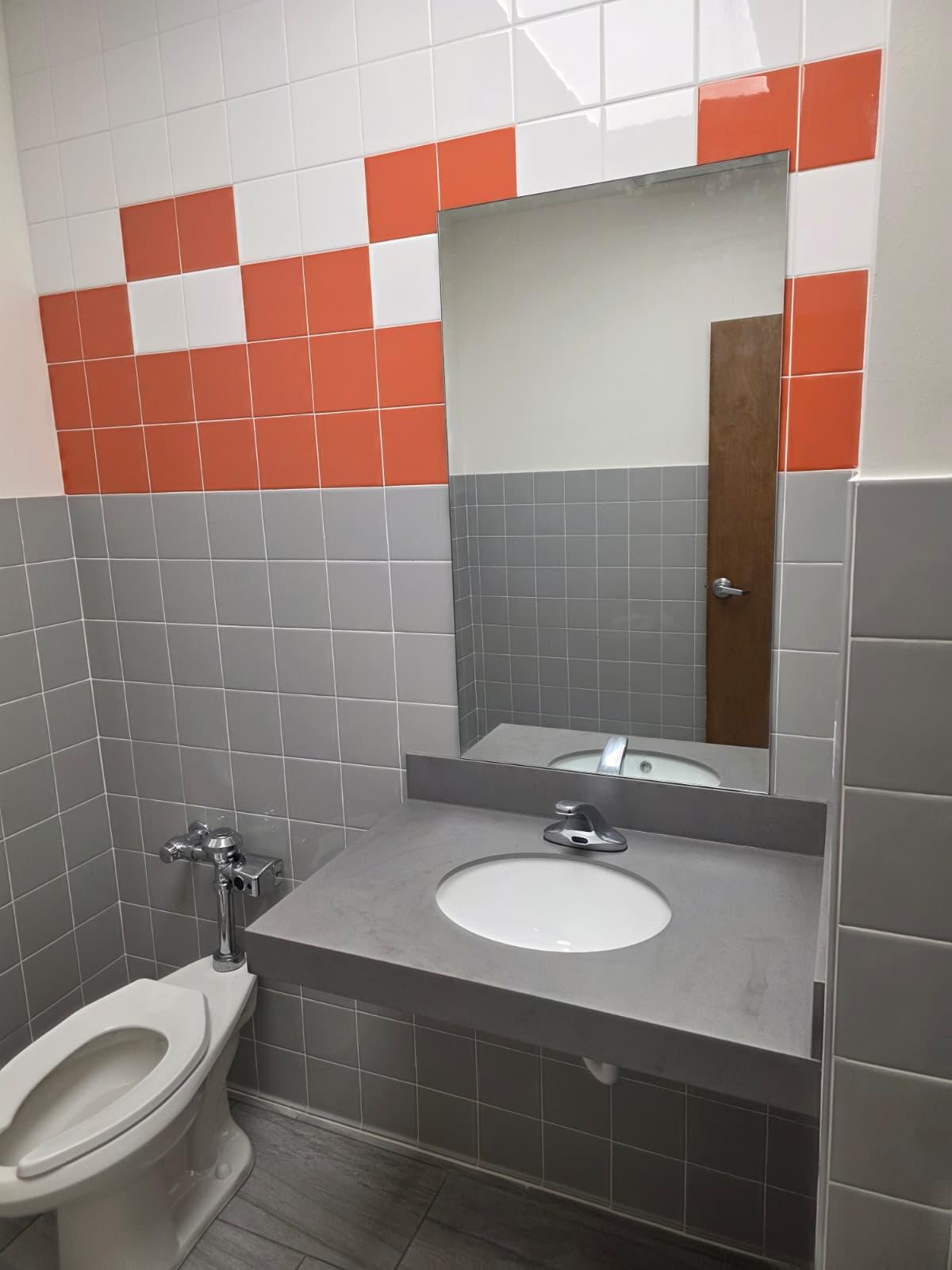 ADA single-user restroom with new fixtures, tile, and accessible layout.