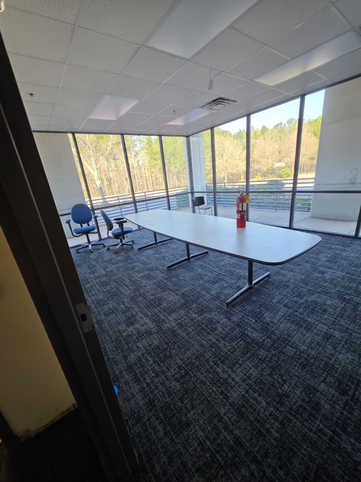 Conference room buildout with matching carpet tile and corner glazing overlooking the property.