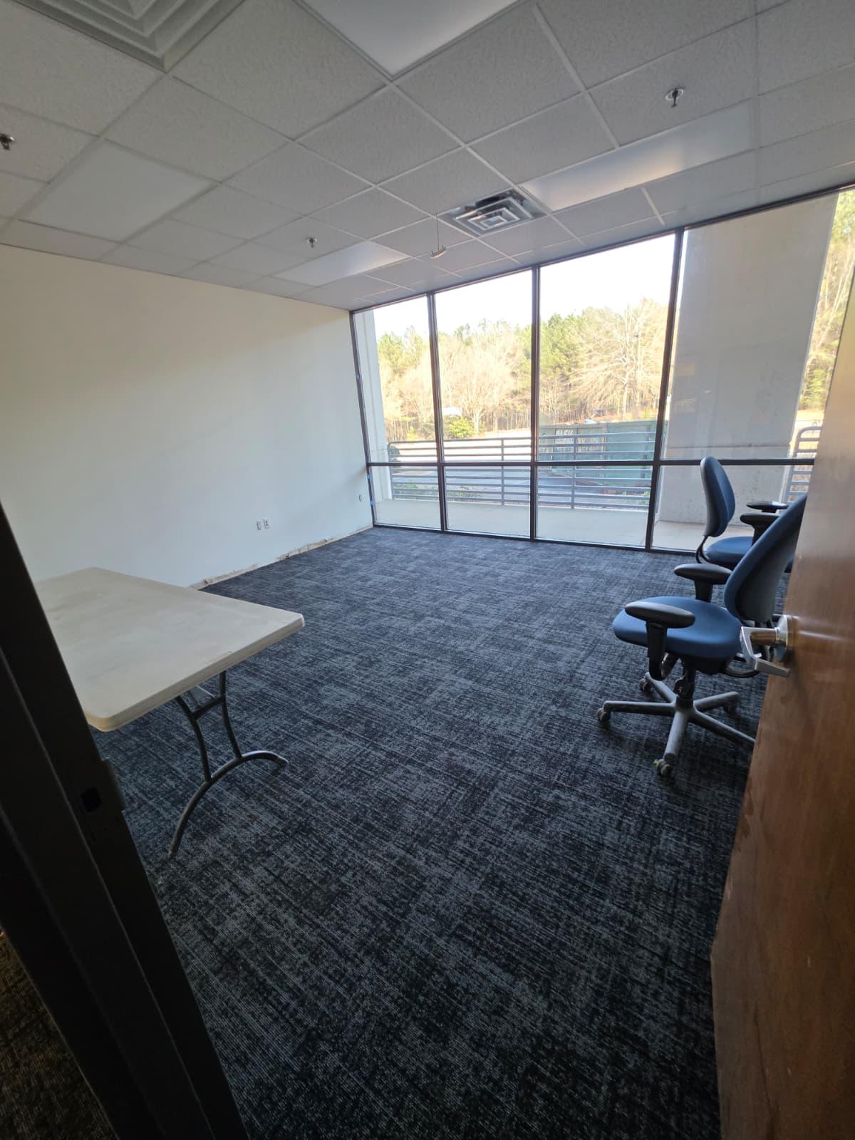 Private office with new carpet tile, perimeter glazing, and clean wall finishes.