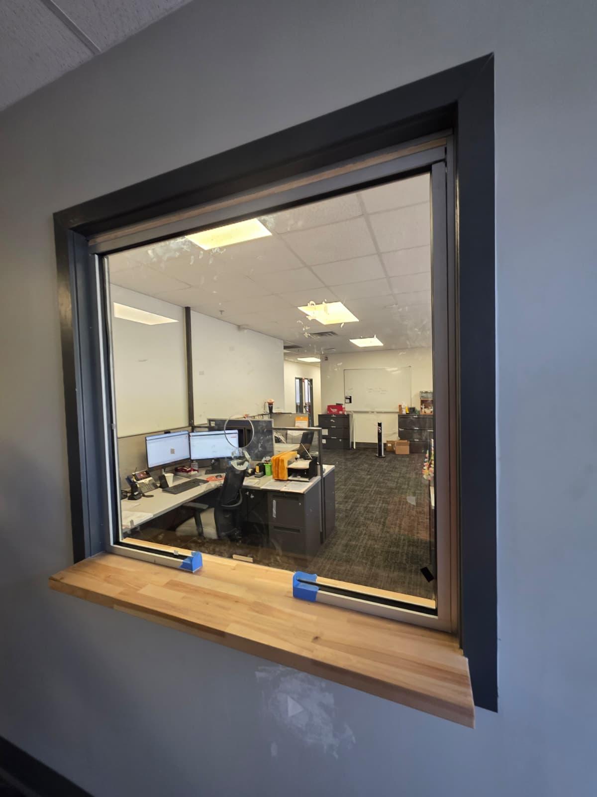 Second transaction window into the bullpen — framed, glazed, and trimmed to match the office package.