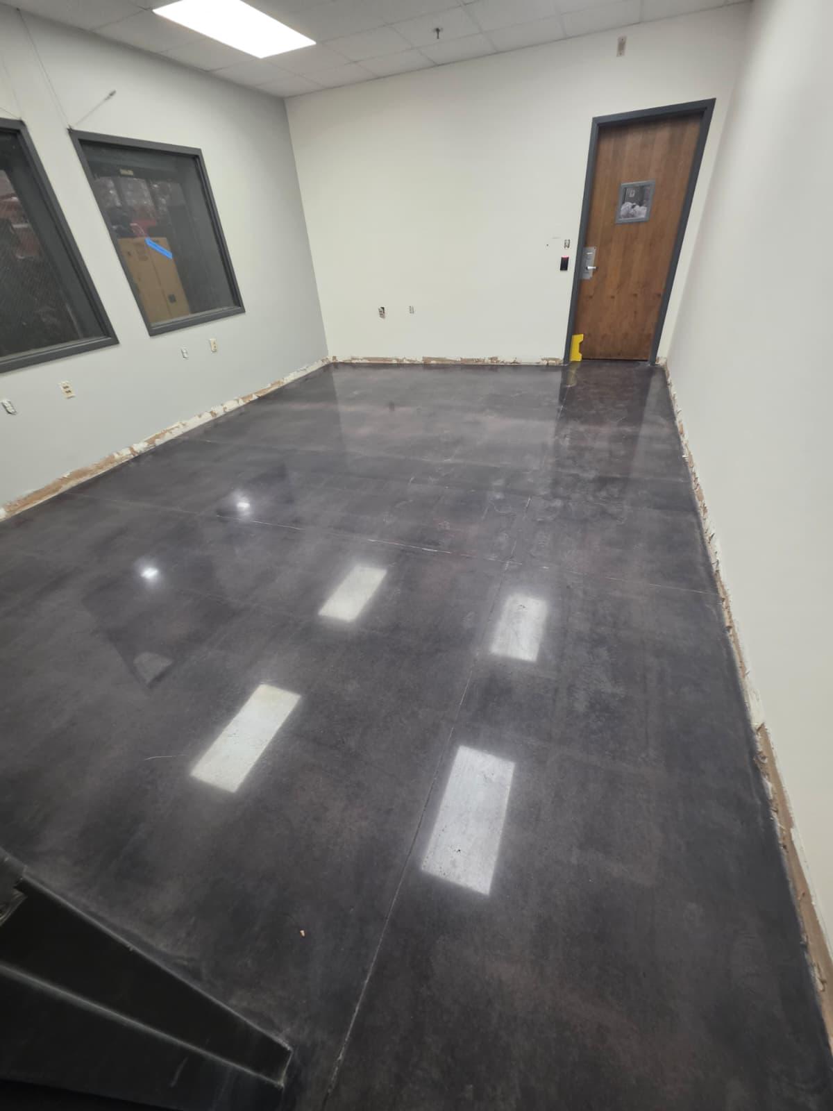 Private office finished in a darker charcoal polish, sealed and burnished to a wet-look shine.