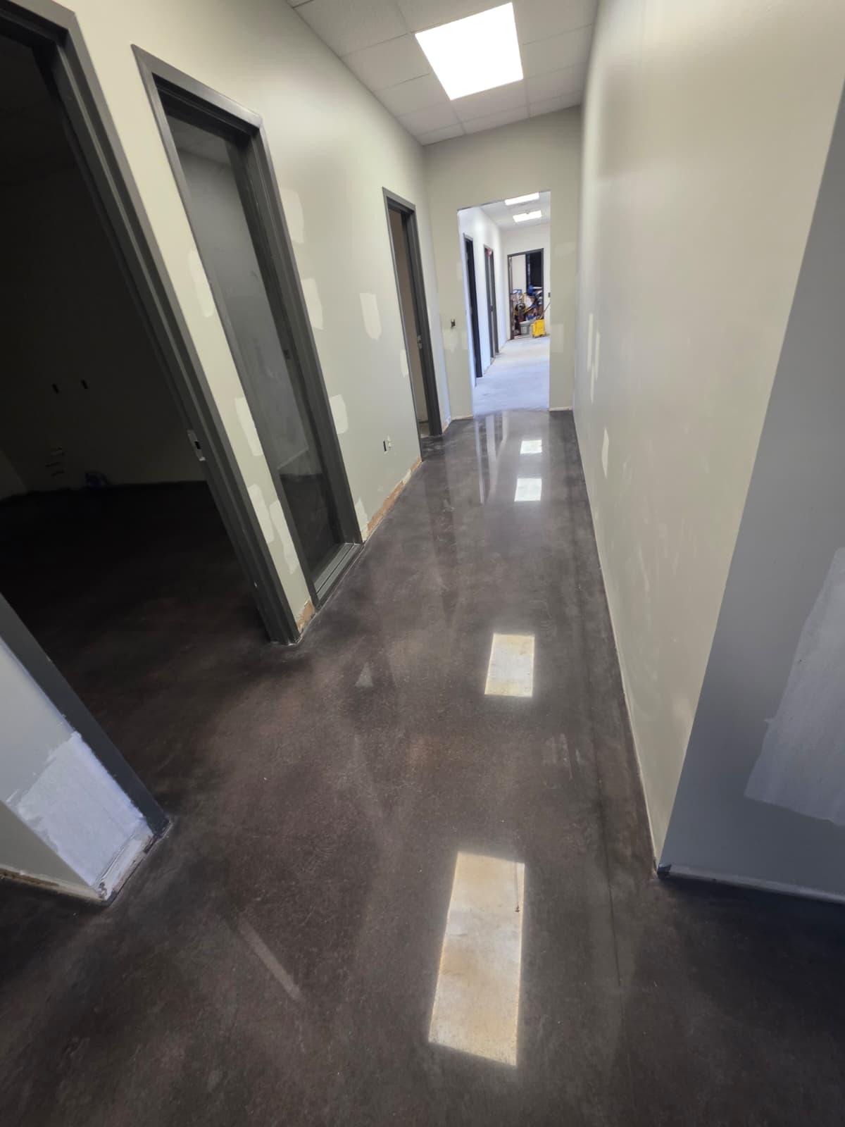 Polished concrete corridor running through the office suite, ready for final paint and trim.