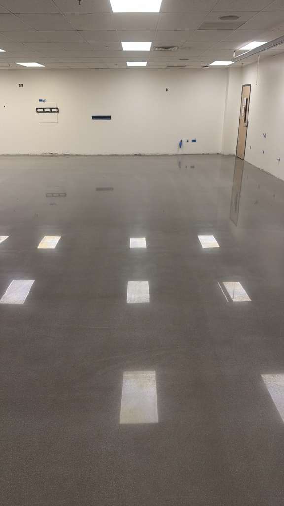 Same training room after our polished concrete process — light-gray finish with a deep, even reflection.